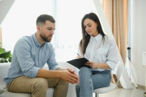 counselor talking with patient on therapy session. depressed man speaking to a therapist