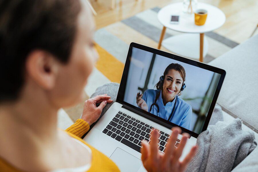 happy female doctor having video call computer with patient who is sitting home