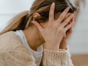 A female with her head in her hands.