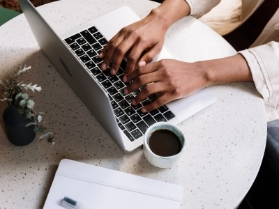 A female's hand's on a laptop working.