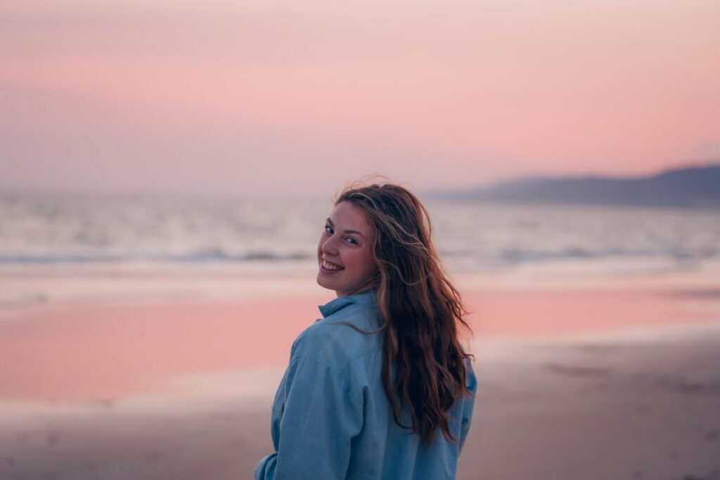 young-woman-walking-on-a-beach-at-sunset