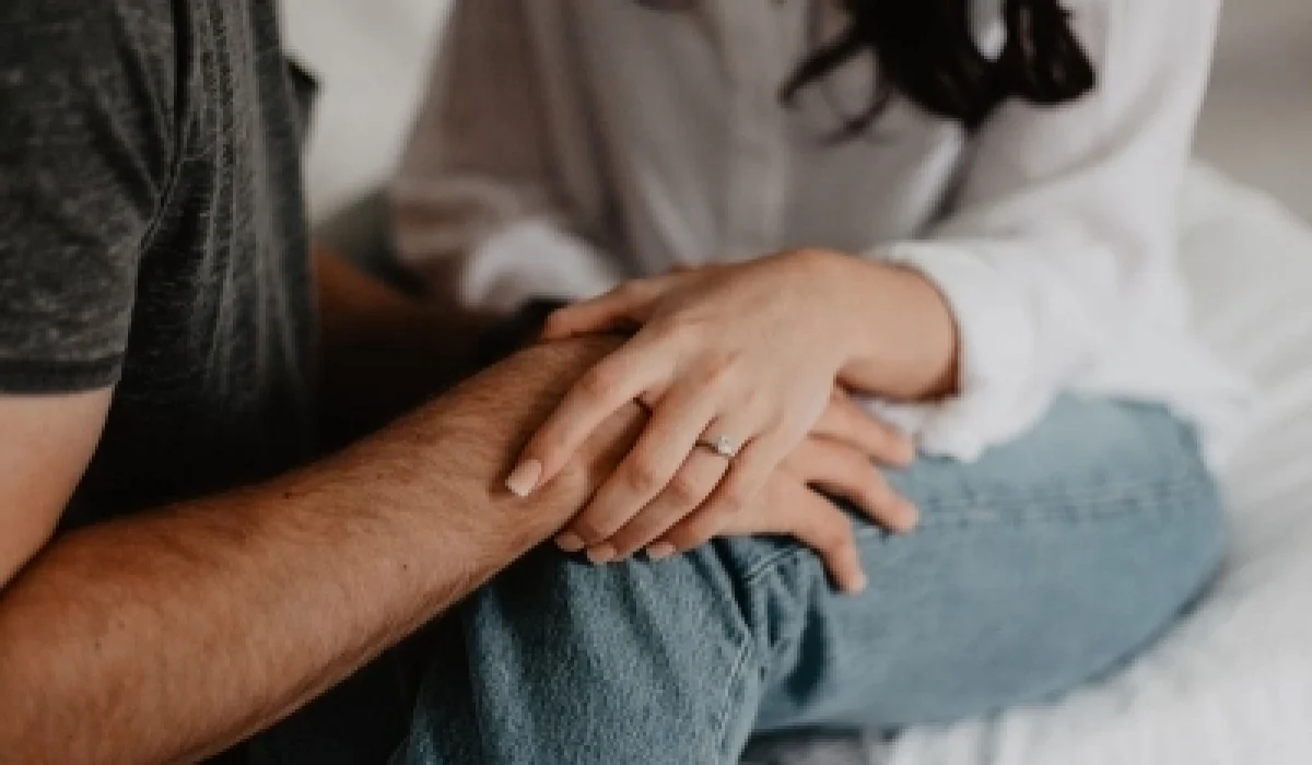 A married couple is holding hands.