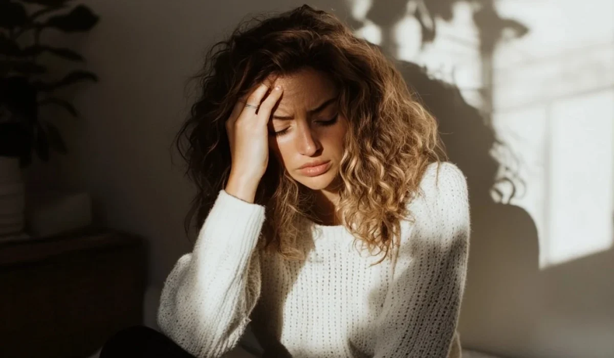 ptsd therapy and trauma therapy - woman sitting on bed holding head