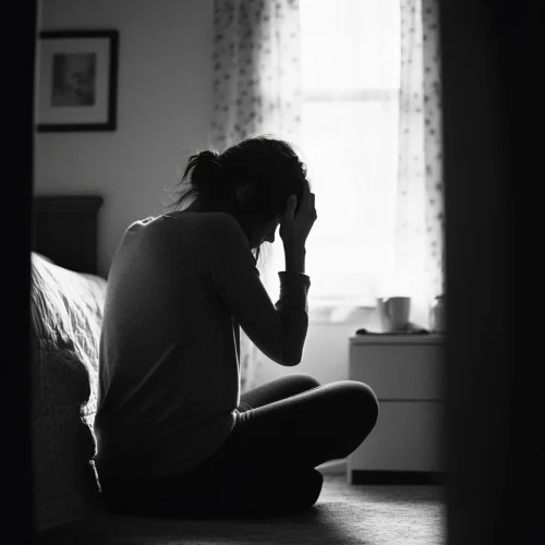 trauma therapy ptsd - woman sitting on floor holding her head